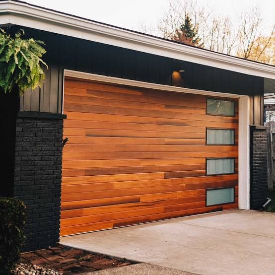 Modern wood-slat garage door with glass accents in Austin TX